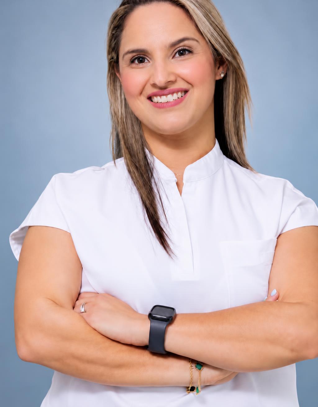 Dra. Jessica Morales, optometrista de Optiplus, sonriendo con su uniforme blanco